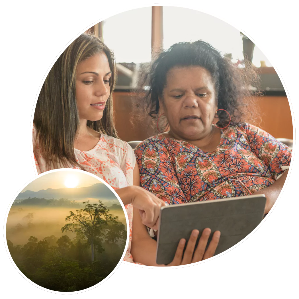 Two women sitting on couch talking and looking at iPad